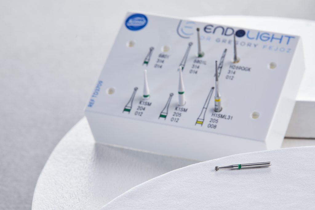 Kit de fraises de Endolight présenté sur un support blanc, avec une fraise boule diamantée verte posée au premier plan