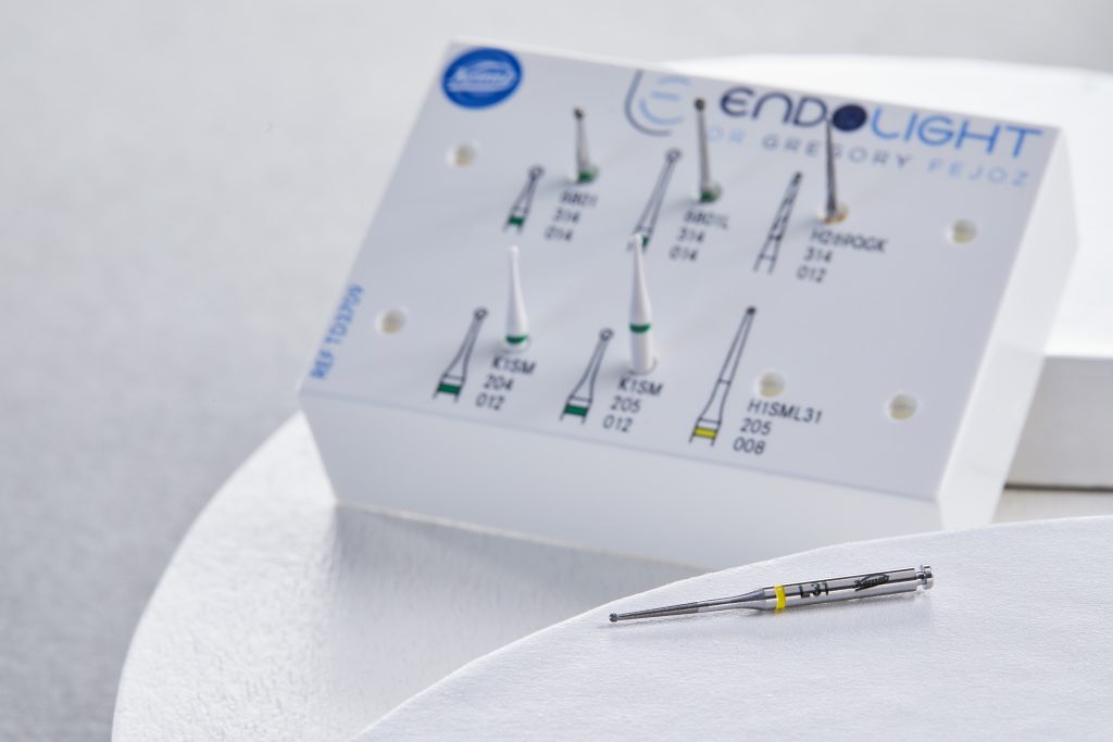 Fraise endodontique H1SML31 à bague jaune, mise en valeur devant le kit de pulpotomie Endolight du Dr Grégory Fejoz.