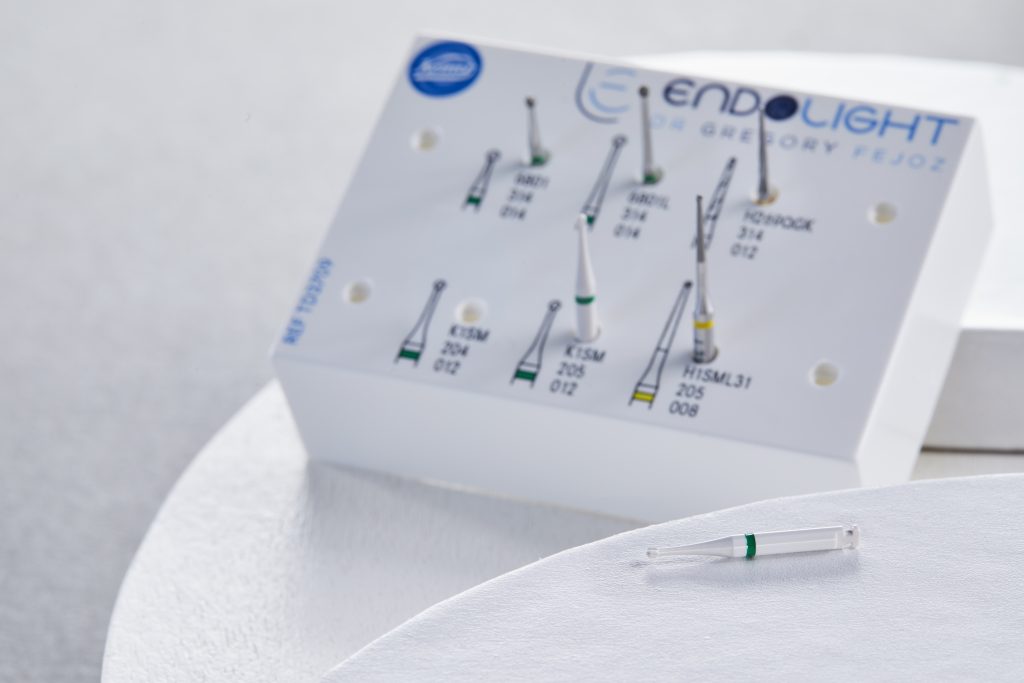 Fraise en céramique K1SM à bague verte, posée sur une surface claire, illustrant une approche minimalement invasive du curetage carieux de la pulpotomie
