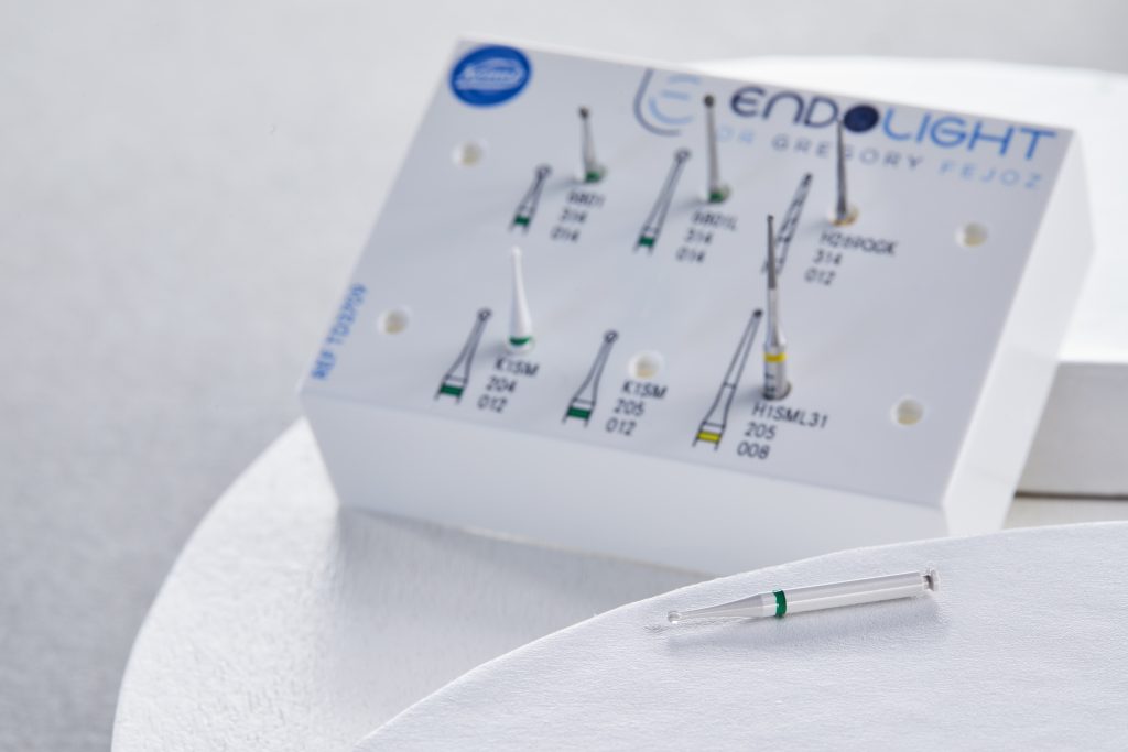 Fraise en céramique K1SM à bague verte, posée sur une surface claire, illustrant une approche minimalement invasive du curetage carieux de la pulpotomie